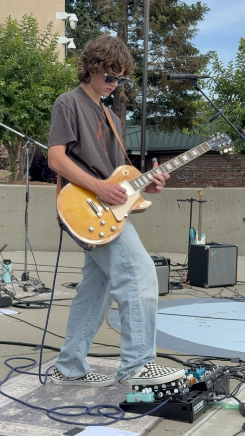 A photo of Brooks Henderson playing a guitar on stage